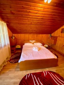 兰卡Casa de Vacanta Catrinel的木制客房内的一间卧室配有一张大床