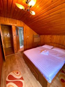 兰卡Casa de Vacanta Catrinel的木制客房内的一间卧室,配有一张床