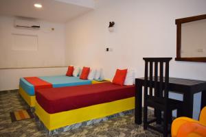 亭可马里金海滩别墅 的客房配有两张带不同颜色枕头的床。