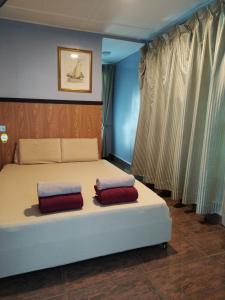 拉瑙Highland Homestay Kundasang的一间卧室配有一张带两个枕头的床