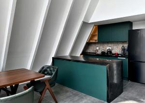 盖贝莱Qafqaz Falcon Chalet的厨房配有绿色橱柜和木桌