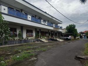 打拉根SPOT ON 92782 Rumah Kost Kita Tarakan的建筑的侧面设有蓝色阳台