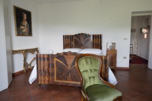 皮耶特拉佩尔托萨La Casa di Penelope & Cirene的一间卧室配有一张床和一把绿色椅子