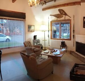埃博森Las Tejuelas Hosteria Patagonica的客厅配有两把椅子和一张桌子