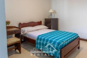 卡利Sandalio Hostal Cali的一间卧室配有一张带蓝白色毯子的床