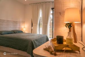 莫罗圣保罗Casa Amerigo的一间卧室配有一张床和一张带台灯的桌子