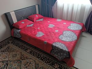 甘榜龙溪Aisy Homestay Putrajaya Cyberjaya KLIA的一张带红色棉被和枕头的床