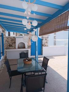 阿斯提帕莱亚镇Queen Stampalia的一间拥有蓝色天花板和桌椅的用餐室