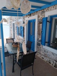 阿斯提帕莱亚镇Queen Stampalia的一间设有蓝色门和桌椅的用餐室