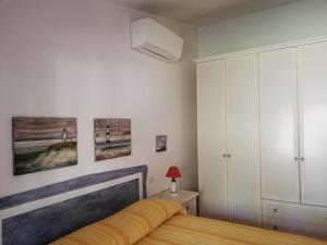 圣帕特雷拉La Sima villa con piscina vista mare San Pantaleo Sardegna的一间卧室配有一张床,墙上挂着一些图片