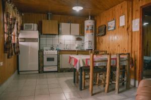 卢汉德库约CABAÑAS DE CHACRAS的厨房配有桌子和白色冰箱。
