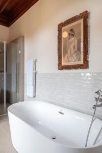 卡斯卡伊斯Chalet Ficalho的带浴缸的浴室,墙上挂着一幅画