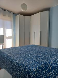 ElmasA un passo da... B&B的一间卧室配有一张带蓝色毯子的床