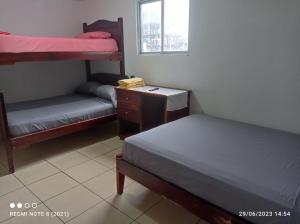 阿塔卡梅斯Hostal SAMARY的一间卧室设有两张双层床、一张桌子和一扇窗户。