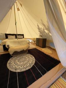 LiivaIntsu Royal Kadakametsa Glämp的一间设有一张桌子和地毯的帐篷的房间