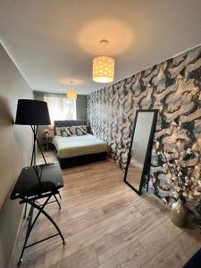 罗金厄姆Comfy double room in Corby的一间卧室设有一张床和一面岩石墙