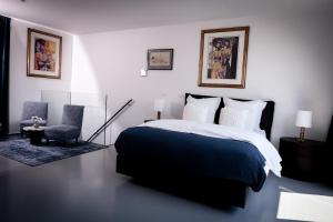 安特卫普Suite Aux Anges的卧室配有黑白床和椅子