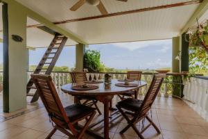 SavanetaUnbounded Horizons:Serene home with Panoramic view的阳台上配有木桌和椅子,阳台设有梯子