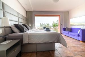 波尔托罗Villa Bellavista II的一间卧室配有一张床和一张紫色沙发