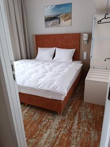 米兹多洛杰Bel Mare Aqua 2 and Garden F104的一张位于小房间的床,配有白色床单