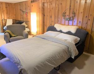 拉瓦尔Montreal - Laval Haven - Entire rental unit的木墙间的床和椅子