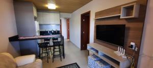 帕罗卡Apartamento Pinheira的厨房以及带大屏幕平板电视的起居室。