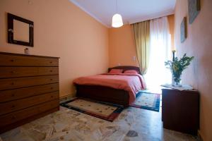 ELATALIA Plastira Lake的一间卧室配有一张床、一个梳妆台和一扇窗户。
