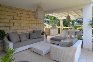 奥尔比亚Villa Summer Luxury Apartment的天井配有沙发、椅子和桌子