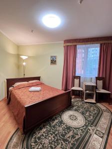 特鲁斯卡韦茨Hotel Premyer的一间卧室配有一张床、一张桌子和一个窗户。