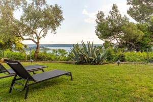 波尔托罗Villa Bellavista I的野餐桌和草地上的长凳