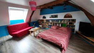 MaignéLa Ménagerie的一间卧室配有红色的床和红色的沙发