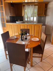 拉夫里翁Luxury Country Home的一张带椅子的木桌和一瓶葡萄酒