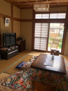 FunehikiTomato House的客厅配有咖啡桌和电视