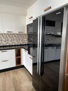 莫纳斯提尔La Villa 91的厨房配有白色橱柜和不锈钢冰箱