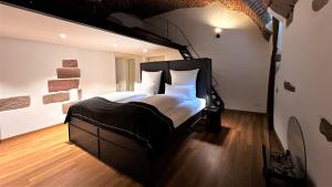 弗莱堡Historical Luxury Homes - Luxus Familien Suite的卧室配有带白色枕头的大型黑色床