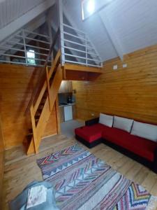 大盐矿镇Tiny H的一间带红色沙发的客厅和楼梯