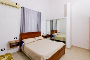 博卡奇卡Hotel Villa Capri的一间卧室配有两张床和镜子