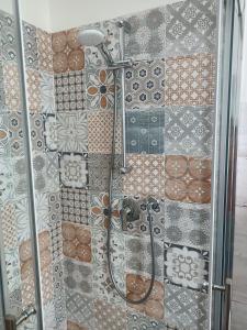 斯培西亚Decò & Retrò apartment的浴室的墙壁上设有瓷砖,浴室内则设有淋浴。