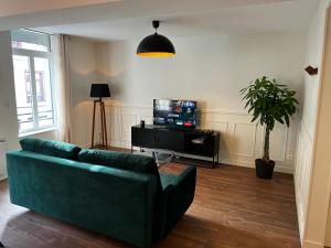 圣奥梅尔Appartement Le Sithiu的客厅配有绿色沙发和电视