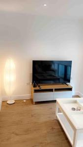 伦敦Tee SweetLux Apartment的客厅配有大屏幕平面电视