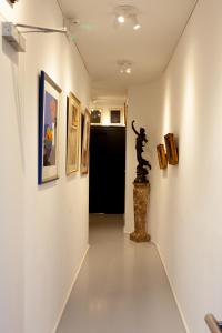 安特卫普Suite Aux Anges的墙上挂有绘画和雕像的走廊