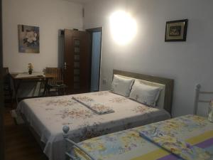 康斯坦察Cazare la mare vila Constanta的一间卧室配有两张床、一张桌子和一张桌子