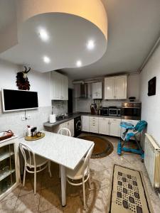 百乐·奥拉内斯蒂Apartament Confort - Baile Olanesti的一个带白色桌子和椅子的大厨房