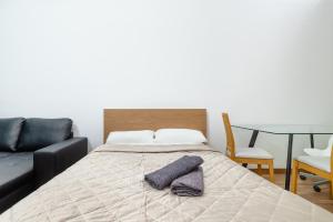 巴塞罗那CAMP NOU & FiRA BUSINESS LOFTS的一间卧室配有一张沙发和一张桌子。