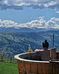 肯佩尼Cabana Dor de Apuseni的坐在按摩浴缸中的女士,享有美景