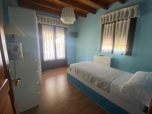 AvínAcogedora casa en Onís - Cangas de Onis的一间拥有蓝色墙壁的卧室,卧室配有一张床和一扇门