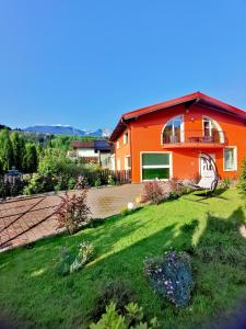 博尔沙Vila Bijou的一座橙色房子,前面有草坪