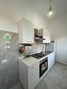 瓦雷泽Sweet home的厨房配有白色橱柜和炉灶烤箱。