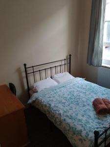伦敦Bell House Hostel的一间卧室配有一张床、一张书桌和一个窗户。