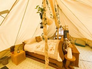 阿什伯恩Hope Cottage Bell Tent Retreat的帐篷内一间卧室,配有一张床
